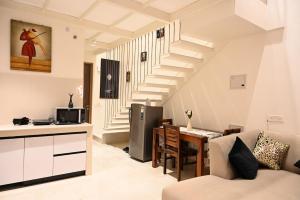 a kitchen and a living room with a staircase at Let's Loft - A Premium Luxury Style Duplex Living in Gurgaon