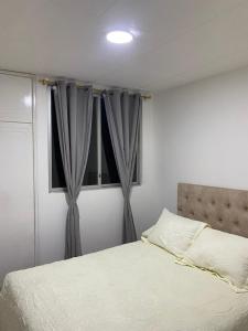 a bedroom with a bed and two windows at Dulce Hogar 01 in Loja