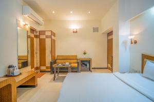 a hotel room with a bed and a chair at Hotel Varun in Guna +140 photos