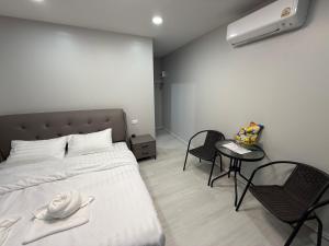 a bedroom with a bed and a table and chairs at บ้านสวนจุกทิพย์ โฮมสเตย์ in Ban Sam Kaeo
