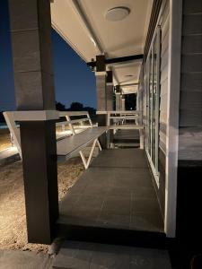 a porch of a house with a bench on it at บ้านสวนจุกทิพย์ โฮมสเตย์ in Ban Sam Kaeo +6 photos