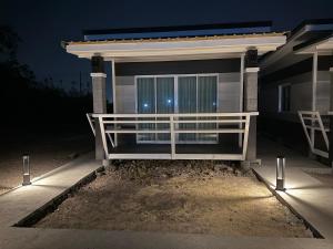 a house with a porch at night with lights at บ้านสวนจุกทิพย์ โฮมสเตย์ in Ban Sam Kaeo