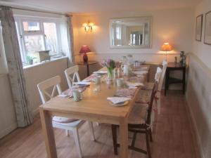 a dining room with a wooden table and chairs at Newton Park Farm in Turvey