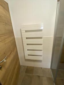 a bathroom with a white wall and a glass door at Haus Caré in Weissensee