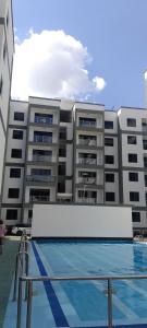 a building with a swimming pool in front of a building at Elite Homes furnished Studio near JKIA in Syokimau