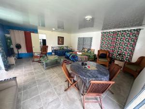 a living room with a table and chairs at Eli Beach House in Vaiorea