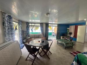 a living room with a table and a couch at Eli Beach House in Vaiorea +7 photos