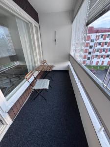 an empty room with two chairs and a large window at Kolmio keskustasta in Ylivieska