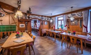 a restaurant with wooden tables and chairs in a room at Gasthof Fallmühle in Pfronten