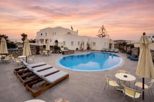a patio with a pool and tables and chairs at Babis Hotel in Karterados