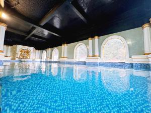 a large swimming pool with blue water in a building at Glenda Tower Moc Chau Hotel in Mộc Châu