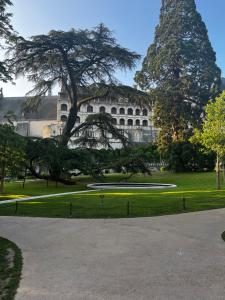 a building with a tree in the middle of a park at Le Grain d Or in Blois