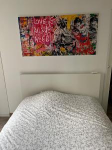 a bed in a bedroom with a poster on the wall at Le Grain d Or in Blois