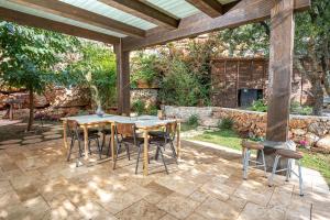 a patio with a table and chairs under a pergola at אזמרה בית אירוח מיוחד עם נוף מדהים ובריכה מחוממת בישוב אמירים in Amirim