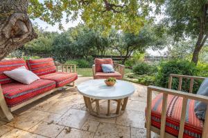 a patio with a couch and two chairs and a table at אזמרה בית אירוח מיוחד עם נוף מדהים ובריכה מחוממת בישוב אמירים in Amirim
