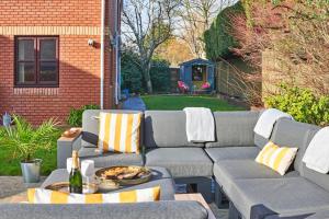 a patio with a couch and a table with a bottle of wine at Finest Retreats - Sea Gables in Exmouth
