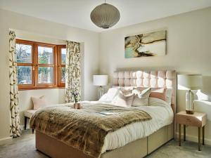 a bedroom with a large bed with a pink headboard at Finest Retreats - Sea Gables in Exmouth