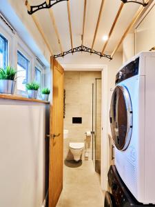 a bathroom with a toilet and a washer and dryer at Finest Retreats - Sea Gables in Exmouth +37 photos