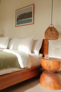 a bedroom with a bed with a wooden headboard and a table at Summer Promo - 2 BR villa, big pool & garden in Kuta Lombok