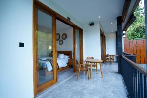 a room with a bed and a table and chairs at Sandat Garden House in Ubud