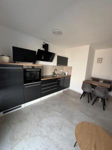 a kitchen with black cabinets and a table with chairs at Ferienwohnung Mina in Münsingen +10 photos