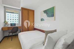 a bedroom with a bed and a desk and a window at Tanea by Kozystay - Braga in Bandung +21 photos
