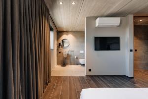 a room with a bathroom with a television and a tub at Coliving - Bord de Meuse - L'écrin Vert in Oupeye