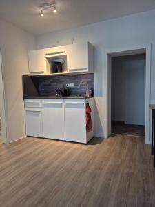 a kitchen with white cabinets and a sink in a room at Hotel Kropper Busch Garni in Kropp