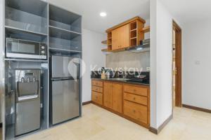 a kitchen with stainless steel appliances and wooden cabinets at Tanea by Kozystay - Braga in Bandung