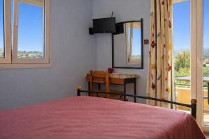 a bedroom with a bed and a window with a view at Agali Beach Apartments Seaside Stay in Chios in Mármaron