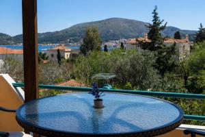 a glass table on a balcony with a view at Agali Beach Apartments Seaside Stay in Chios in Mármaron