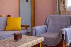 a living room with two chairs and a table at Agali Beach Apartments Seaside Stay in Chios in Mármaron +38 photos