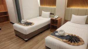 a hotel room with two beds with hats on them at SVJ Hotel in Cebu City