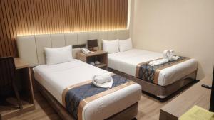 a hotel room with two beds and a table at SVJ Hotel in Cebu City