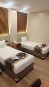 a hotel room with two beds and a table at SVJ Hotel in Cebu City