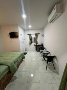 a bedroom with a bed and a table and a tv at ไสวรีสอร์ท Sawai Resort in Ban Khao Noi