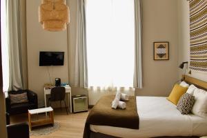 ein Schlafzimmer mit einem Bett, auf dem ein Teddybär liegt in der Unterkunft Hotel Du Parlement in Brüssel
