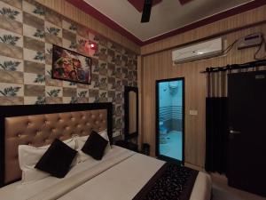 a bedroom with a large bed and a glass door at Hotel Jalsa in Haridwār