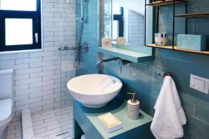 a blue bathroom with a sink and a toilet at Soleado Luxury Villas in Skala Fourkas +62 photos