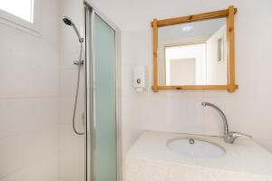 a bathroom with a shower and a sink and a mirror at SPNI Har Hanegev Field School in Mitzpe Ramon