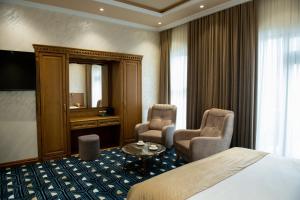 ein Hotelzimmer mit einem Bett, zwei Stühlen und einem Tisch in der Unterkunft Aivazovsky Congress Hotel & Spa in Gjumri