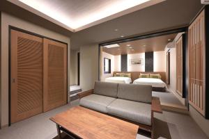 a living room with two beds and a couch at HOTEL THE7 Kumamoto in Kumamoto