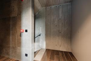 a room with a concrete wall and wooden floors at Coliving - Bord de Meuse - L'écrin Vert in Oupeye +30 photos
