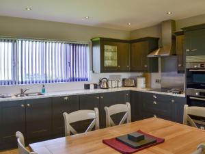 a kitchen with a wooden table and a wooden tableablish at Aimmee's Lodge - Ukc2203 in Doddington