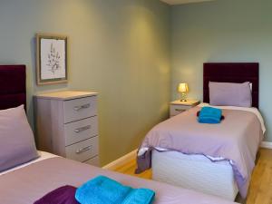 a bedroom with two beds with blue towels on them at Aimmee's Lodge - Ukc2203 in Doddington +9 photos