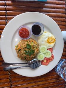 a plate of food with a fried egg and rice at Angghy Garden Tetebatu in Tetebatu