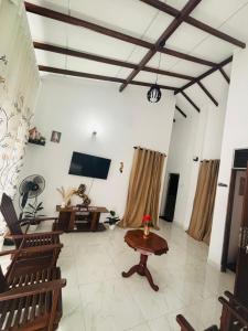 a living room with chairs and a table and a tv at HotelSide Residences in Negombo