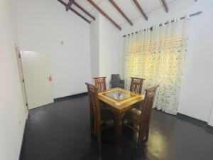 a dining room with a table and two chairs at HotelSide Residences in Negombo