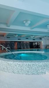 a large swimming pool in a large building at Hello Mountains Apartaments Sinaia in Sinaia