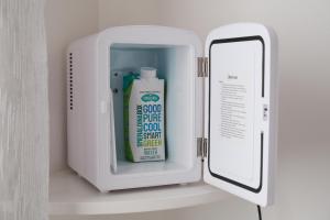 a container with a bottle of cleaning fluid next to a mirror at B&B a due passi dal centro in Castelsardo